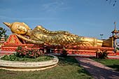 Vientiane, Laos - Pha That Luang, large gilded reclining Buddha within the temple area. 